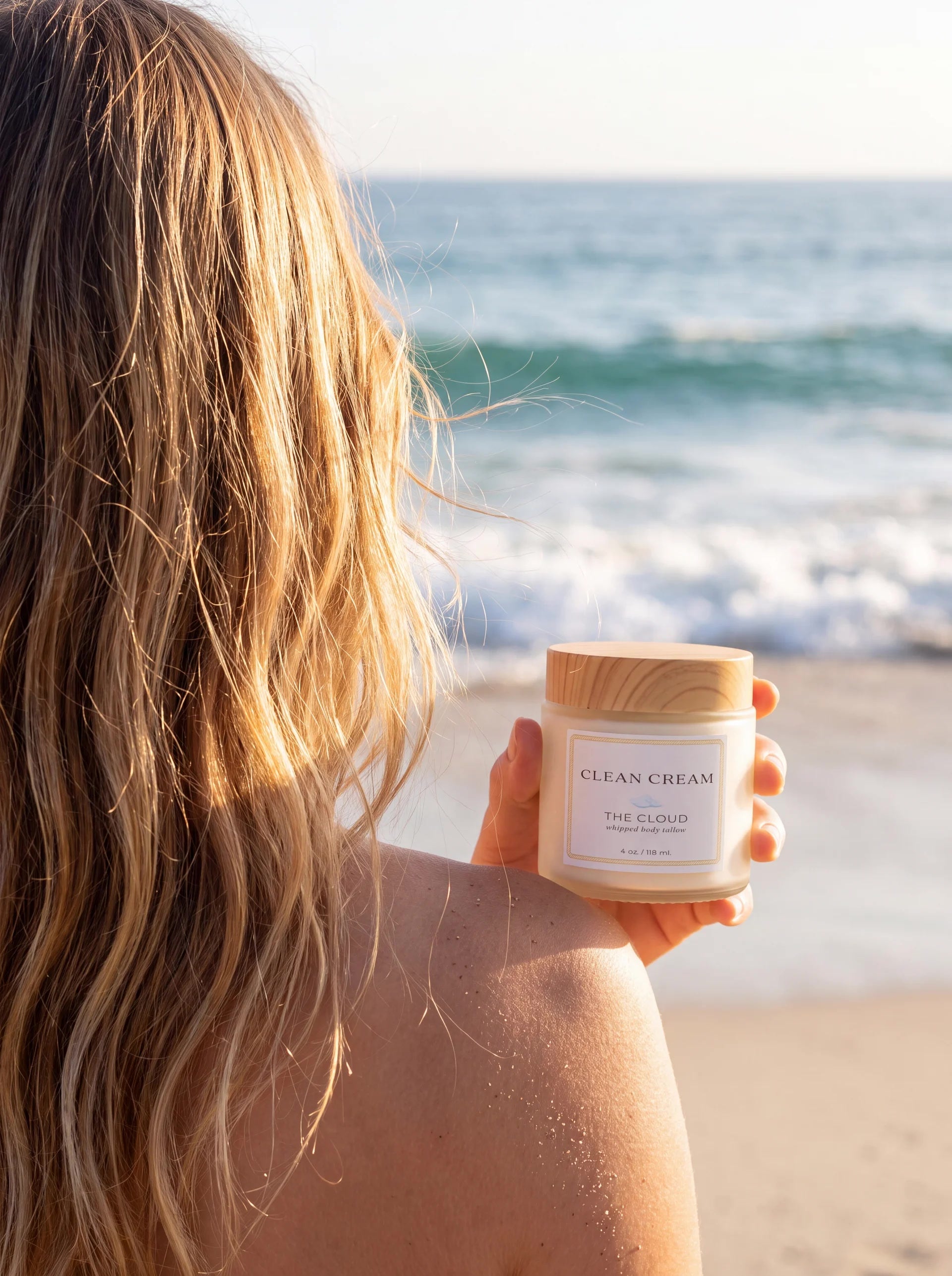 A jar of Clean Cream held at the shoreline